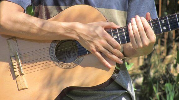 Chico con guitarra española en la mano.